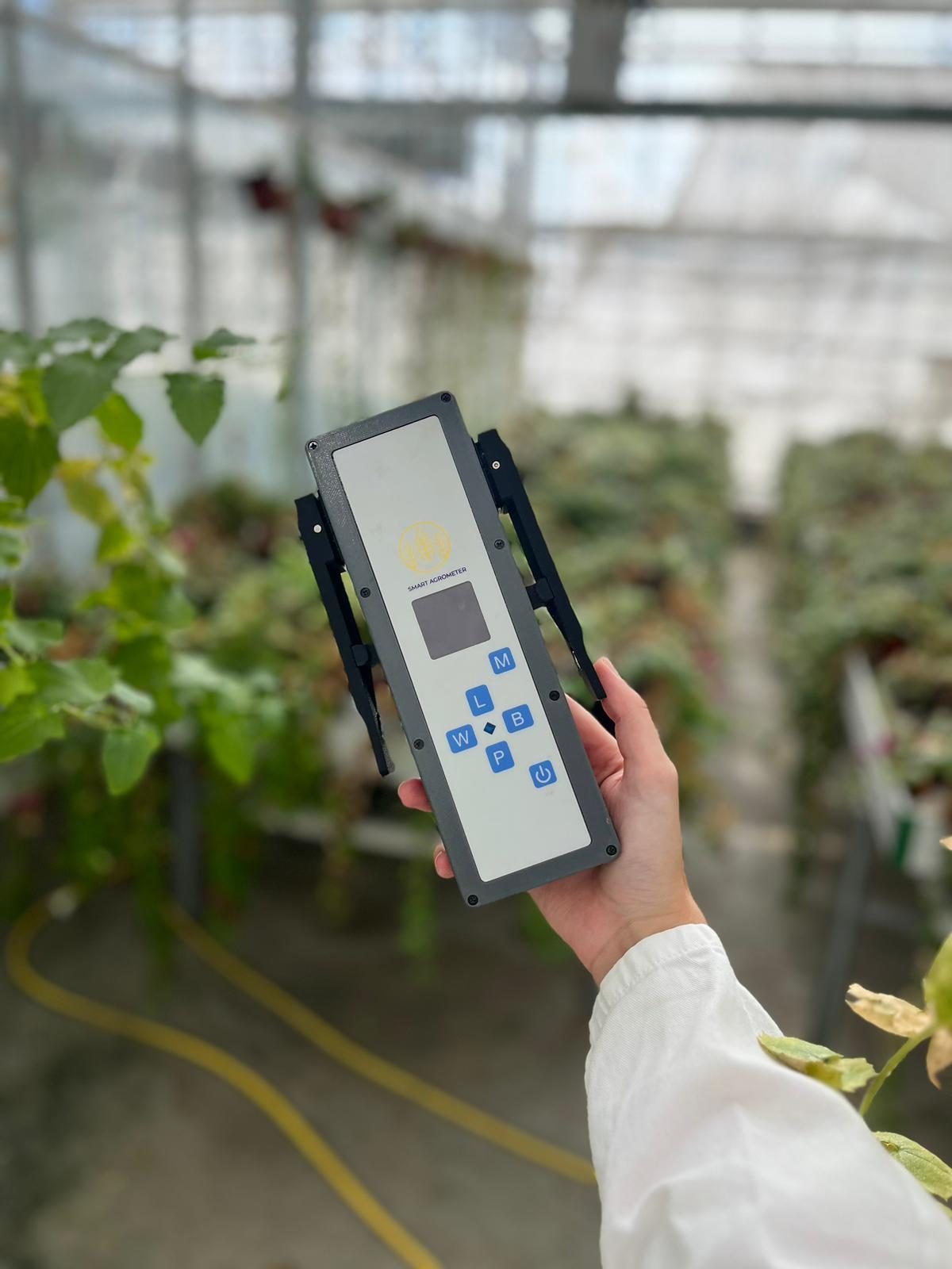 SmartAgrometer prietaisas rankoje, matuojamas augalo lapas
